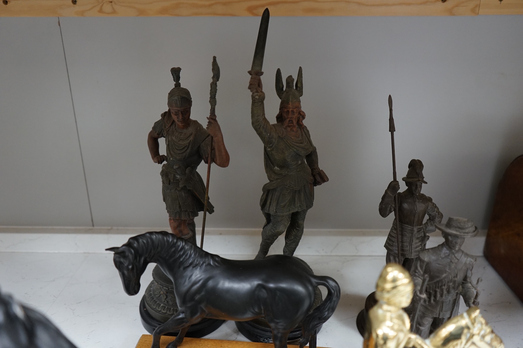 A pair of spelter figures a brass door stop two models of horses two other figures and a large group of toy soldiers. Tallest 45cm.